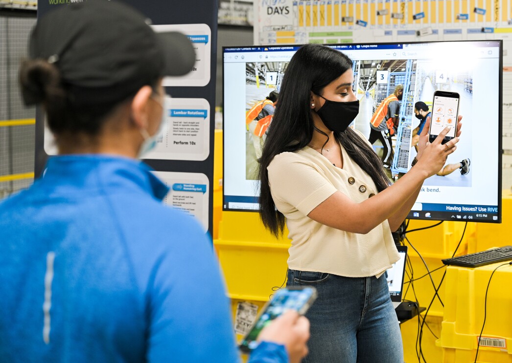 An image of an Amazon employee in a fulfillment center demonstrating how WorkingWell works.