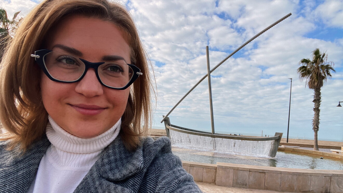 Primer plano de Olha Hanziienko delante de la playa. 