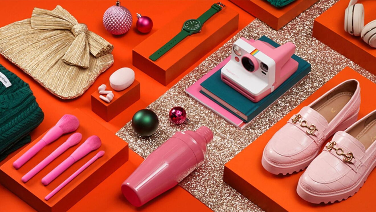 A flatlay of pink and green themed gift items arranged on a red background.