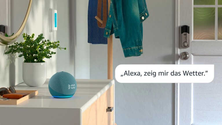 Ein Bild eines blauen Echo-Geräts, das auf der Theke neben der Haustür steht. Das Gerät zeigt die Zeit „3:00“ an und rechts befindet sich ein Textfeld mit der Aufschrift „Alexa, stelle die Temperatur auf 72“.