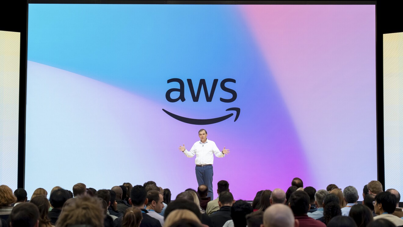 Matt Garman on stage in front of an audience with AWS in the background