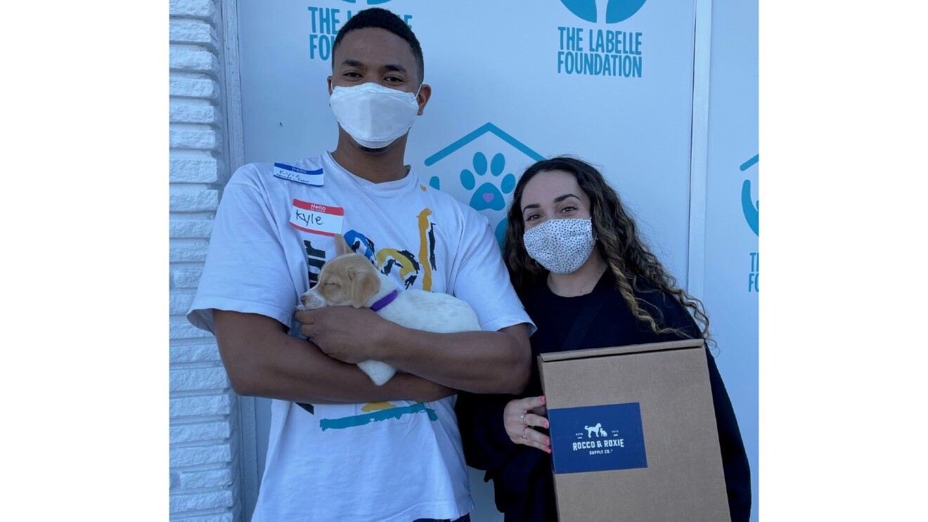 Owners hold their new adopted puppy and a Rocco & Roxie box.