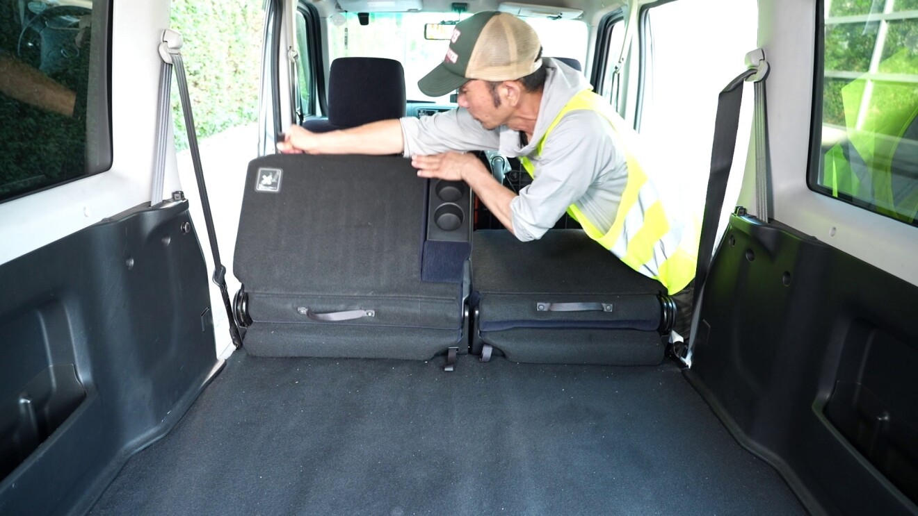 後部座席を倒し荷物が積めるように準備している男性