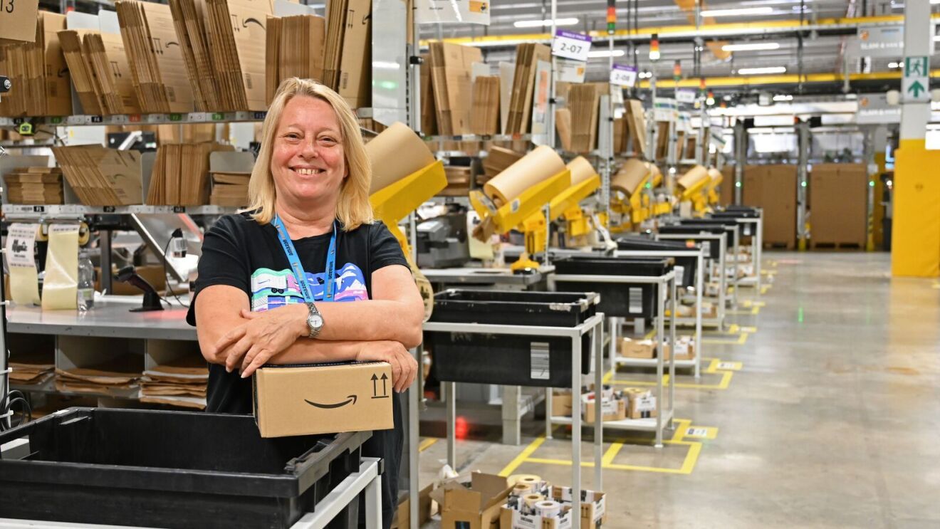 A woman stands amidst boxes in an Amazon warehouse