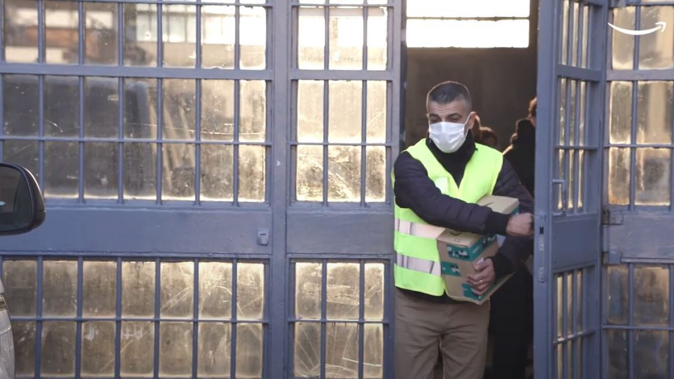 Corriere esce dal carcere di San Vittore con un pacco Amazon in mano