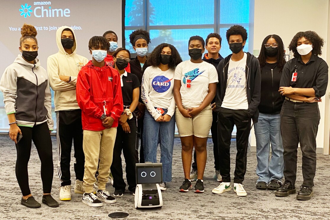 An image of Amazon's Greene Scholars Program participants with an Amazon Astro robot.