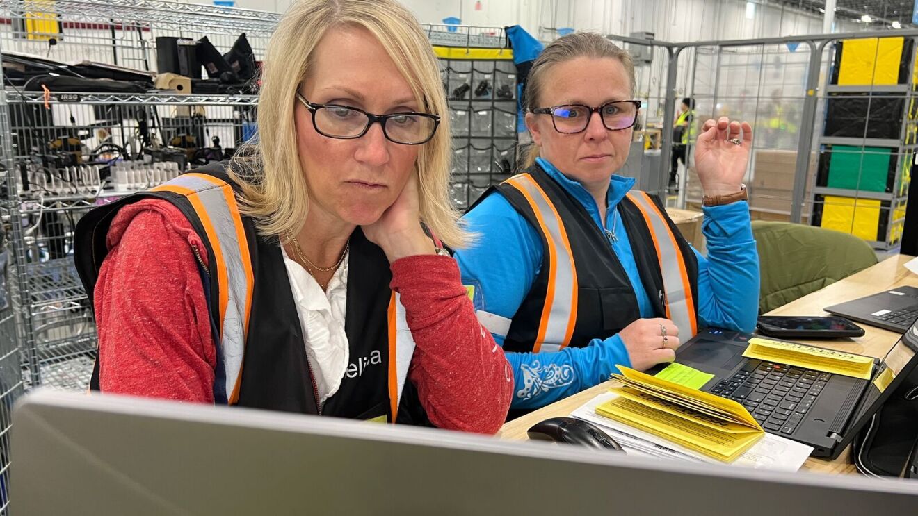 An image of a woman, an Amazon Delivery Service Partner, in a work vest standing in front of a delivery van.