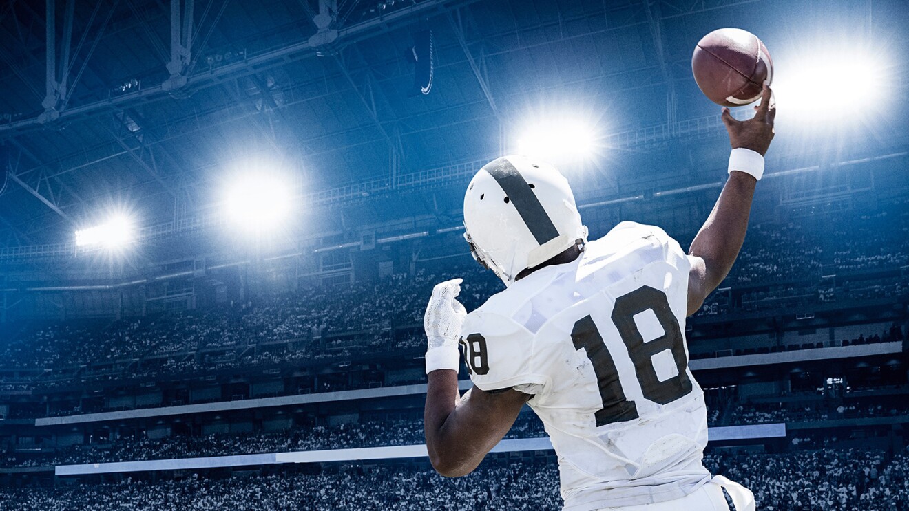 一个足球运动员跳起来伸手去接球的画面。