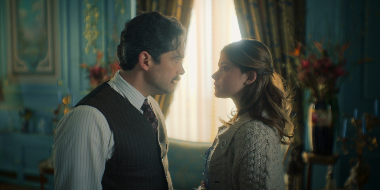 Man and woman staring at each other in front of window 