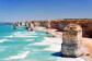A beach with rock formations. The sea is blue and green. 