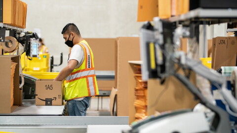 Ops employee with a face mask, packing an order in the Singapore fulfillment centre