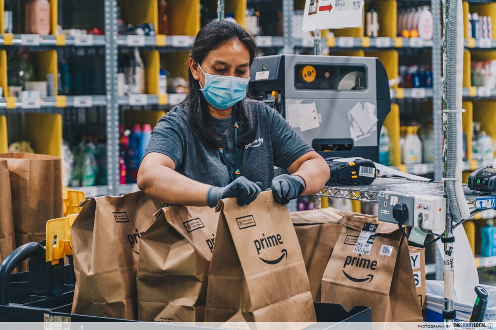 An employee printing and pasting delivery codes onto each order