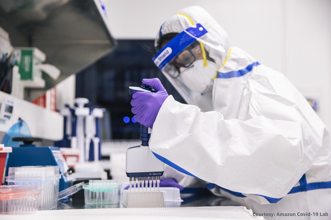 Person in full PPE doing testing in a laboratory setting