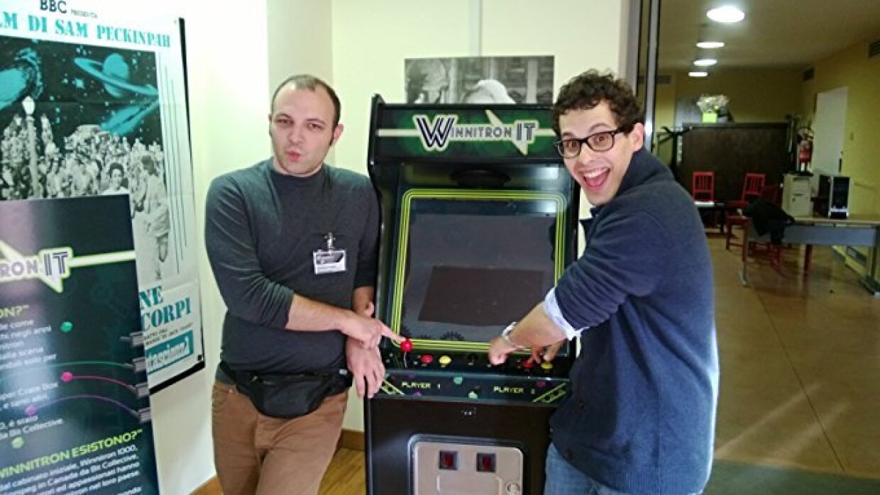 Due ragazzi di fronte a un videogioco in un ufficio.
