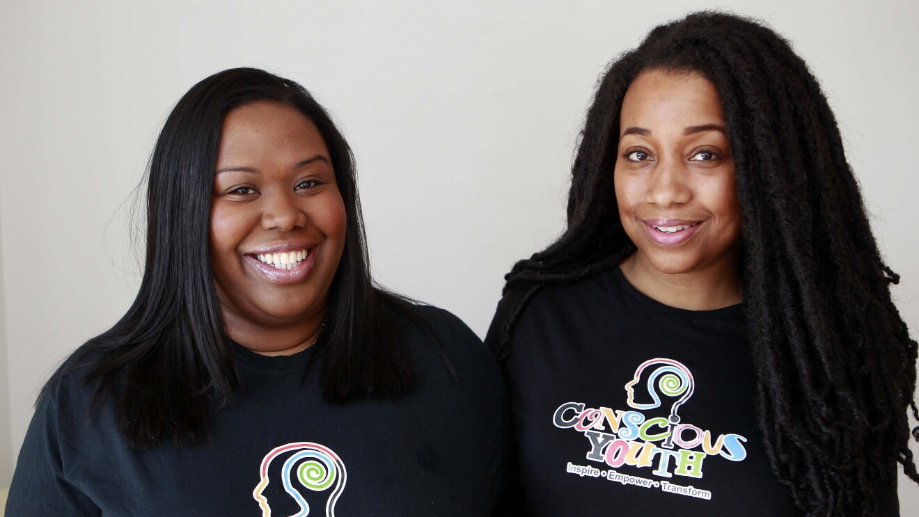An image of Sophie and Serena from Conscious Youth, they are wearing t shirts with their logo on it.