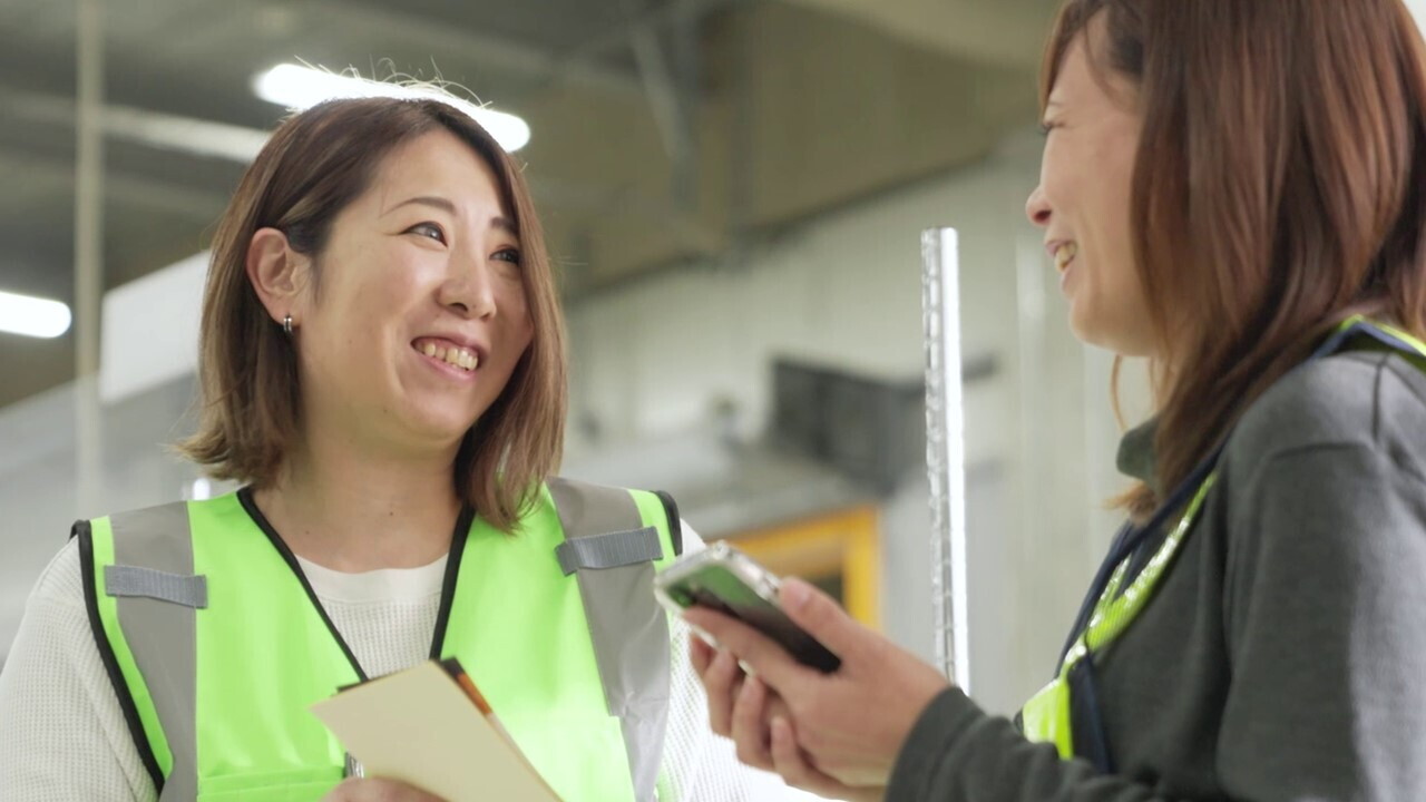 共に働く女性ドライバーと笑顔で会話する中村さん