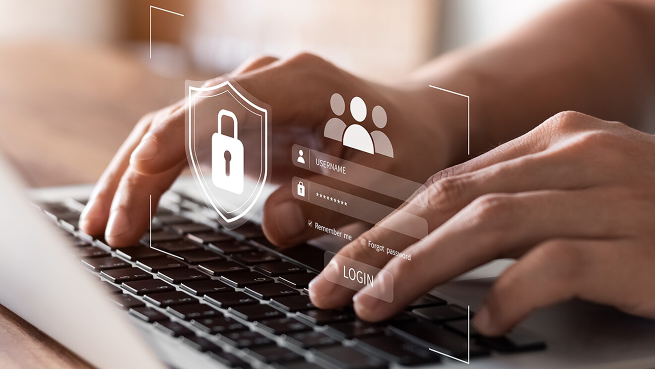 Una foto de dos manos tecleando un teclado. De la imagen sale un logo con un candado de seguridad. 