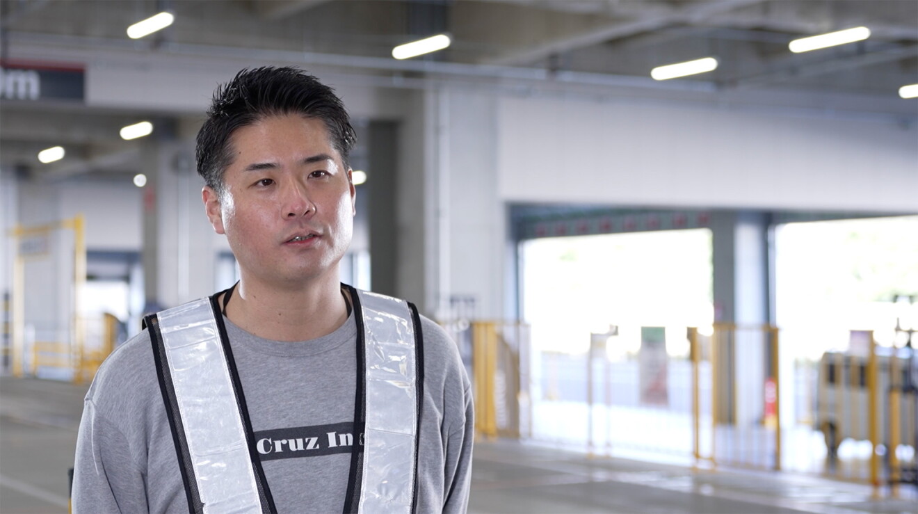 作業用の白いベストを着た男性が作業場に立っている