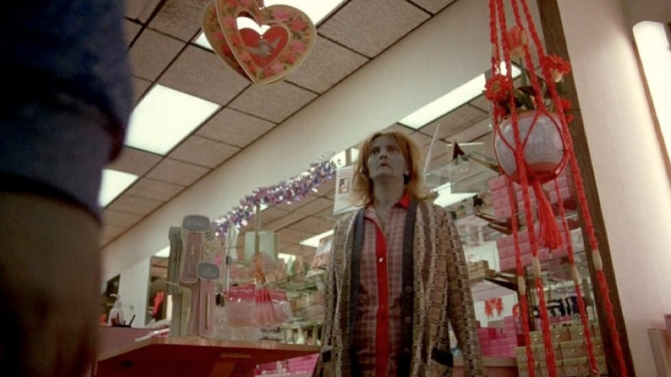 Zombie in patterned coat surrounded by pink and red store displays