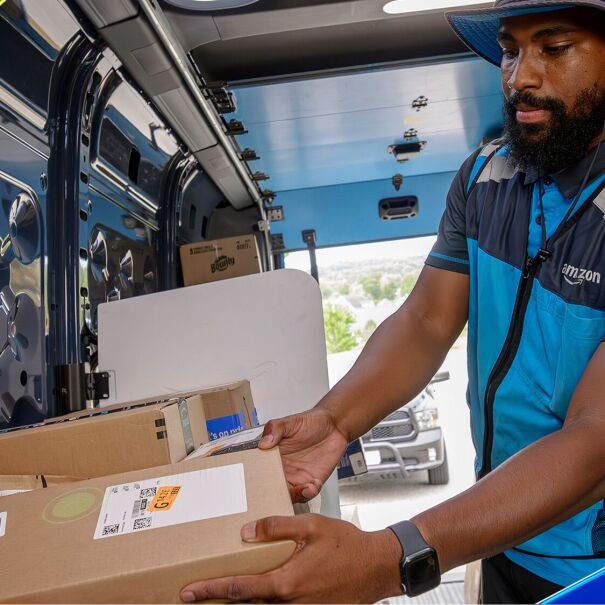 An Amazon delivery driver selecting packages that are sorted with VAPR technology.