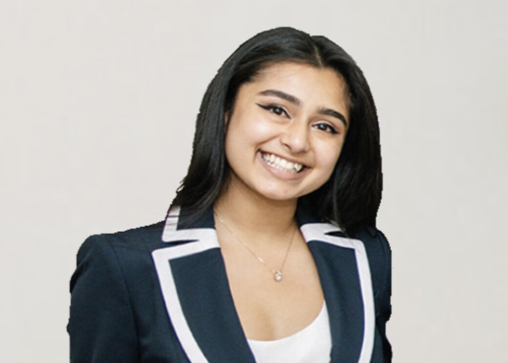 An image of a young woman smiling for a photo with a white background behind her.