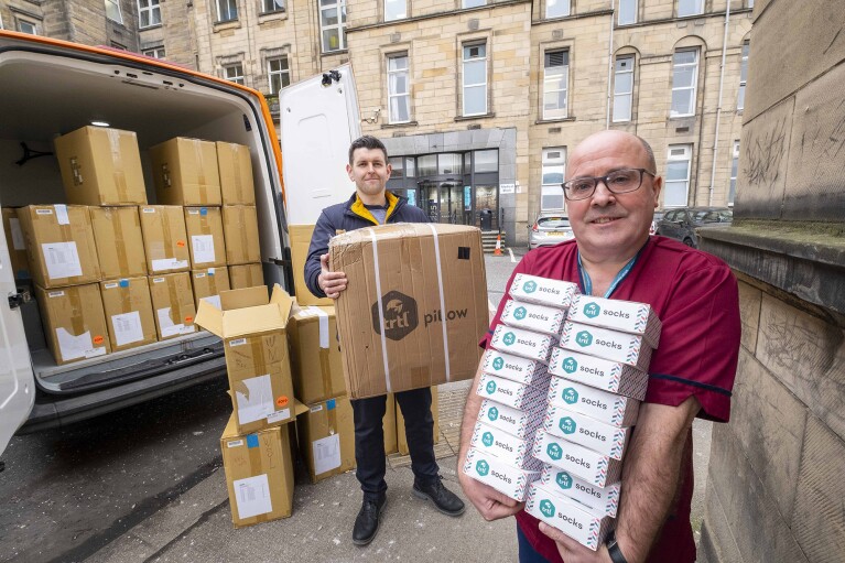An image of the trtl team donating boxes of their products to key workers. They are holding stacks of boxes which they are unloading from a van.