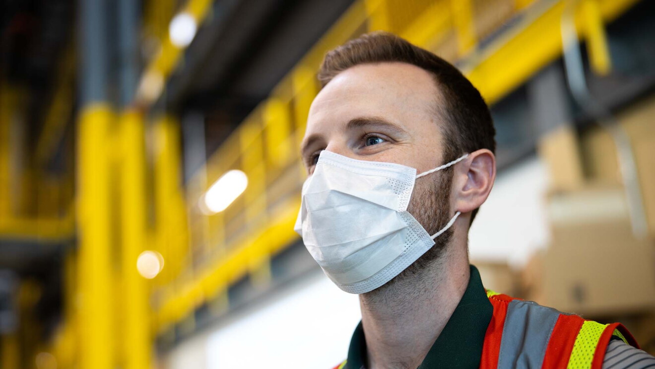 Amazon associate in a fulfillment center following additional safety proceedures in response to the COVID-19 pandemic