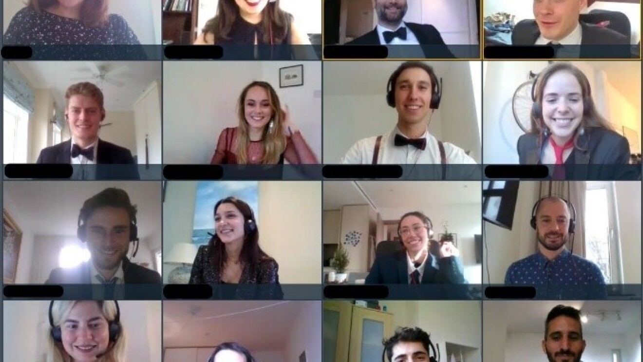 Männer und Frauen mit Headsets in einer Videokonferenz lachen in die Kamera.