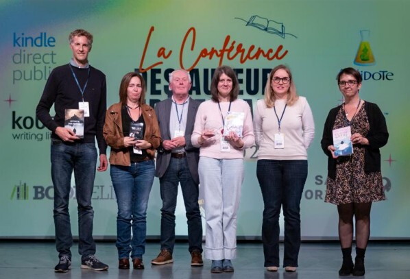 Six écrivains tenant des livres lors d'une conférence Kindle Direct Publishing