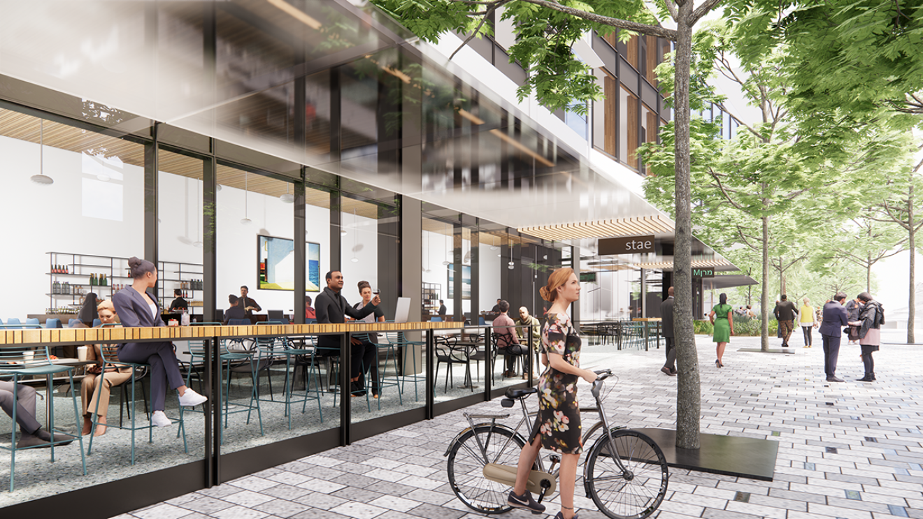 A rendering of the future Bellevue 600 site shows a woman wearing a floral bicycle and her bicycle. Behind her, people enjoy an open-air patio.