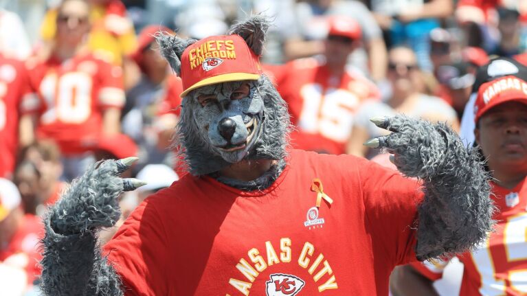 Kansas City Chiefs superfan in wolf costume and team gear at game.