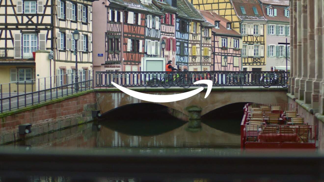 Image of bicycle delivery crossing a bridge in a European town