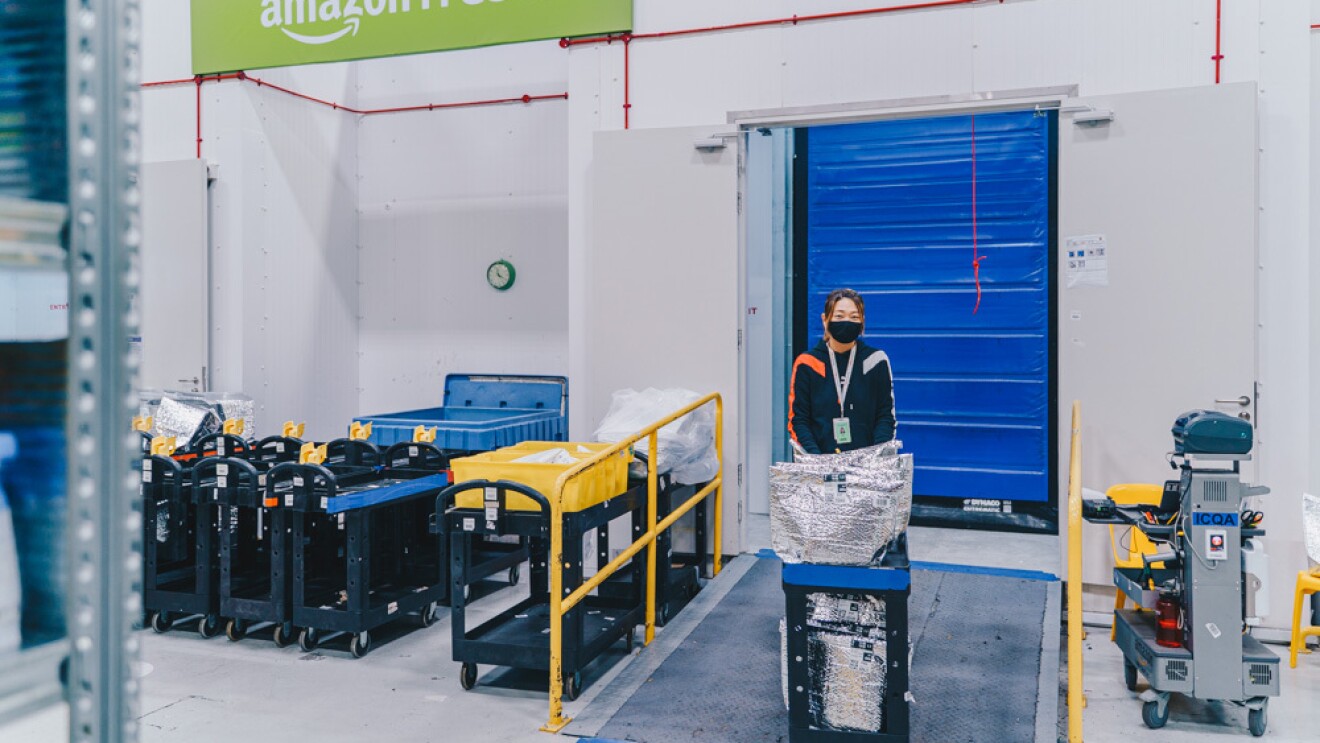 An employee pushing a trolley out of the chiller and freezer