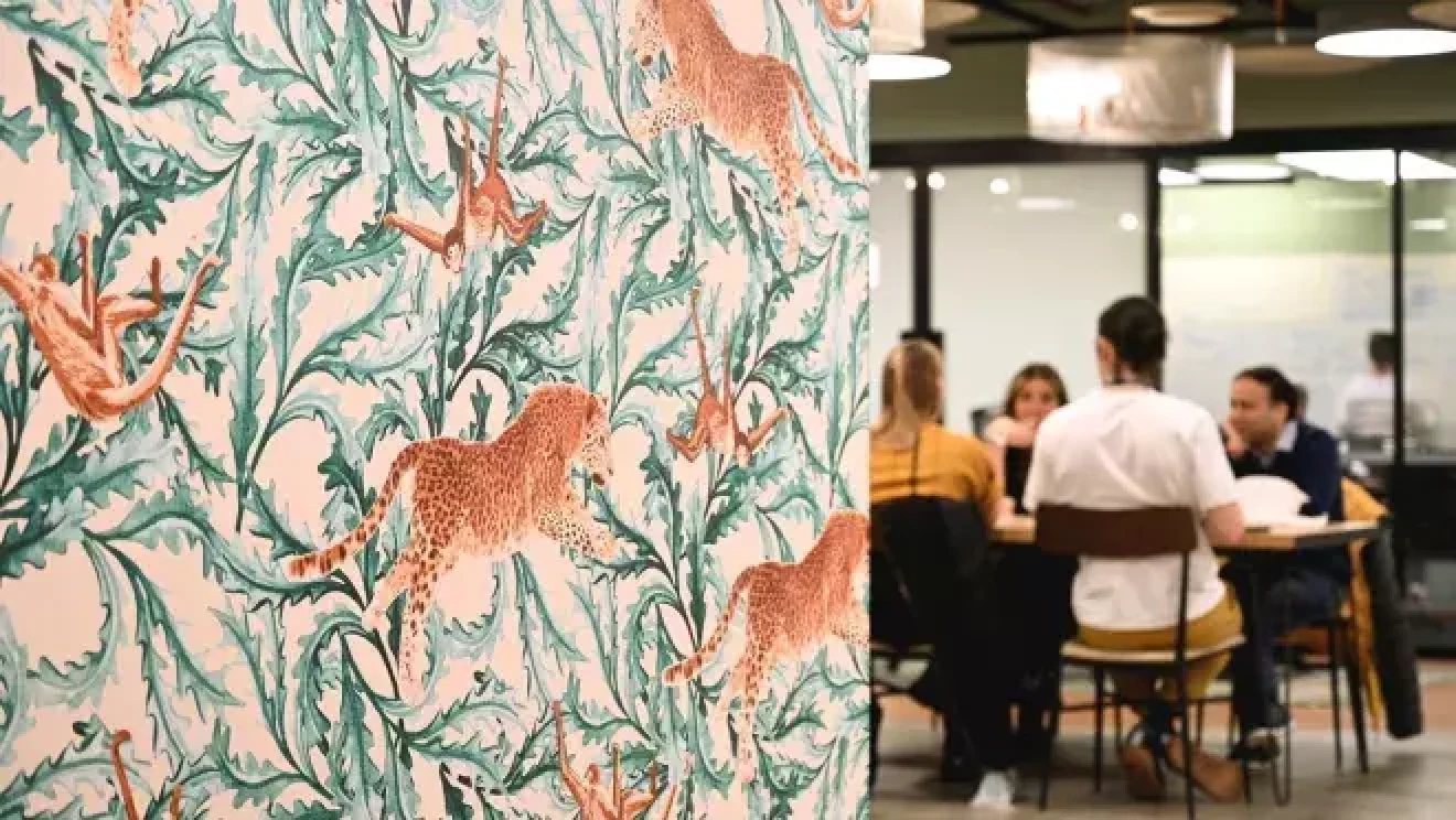 複数の豹と草がデザインされた壁紙。その奥に人々が座っているテーブルが見える