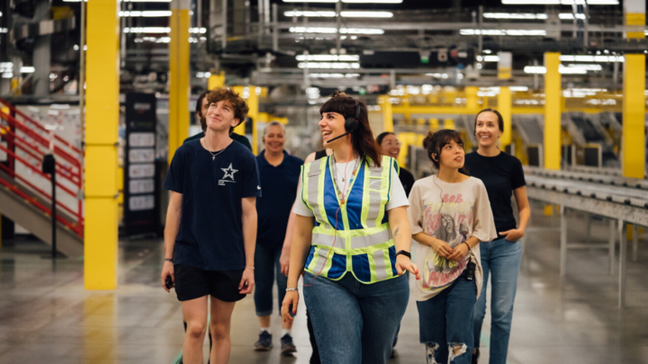 Équipe diverse marchant dans un centre de distribution par de vives lumières au plafond