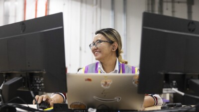 一张亚马逊员工在台式电脑和笔记本电脑上进行在线课程的照片。