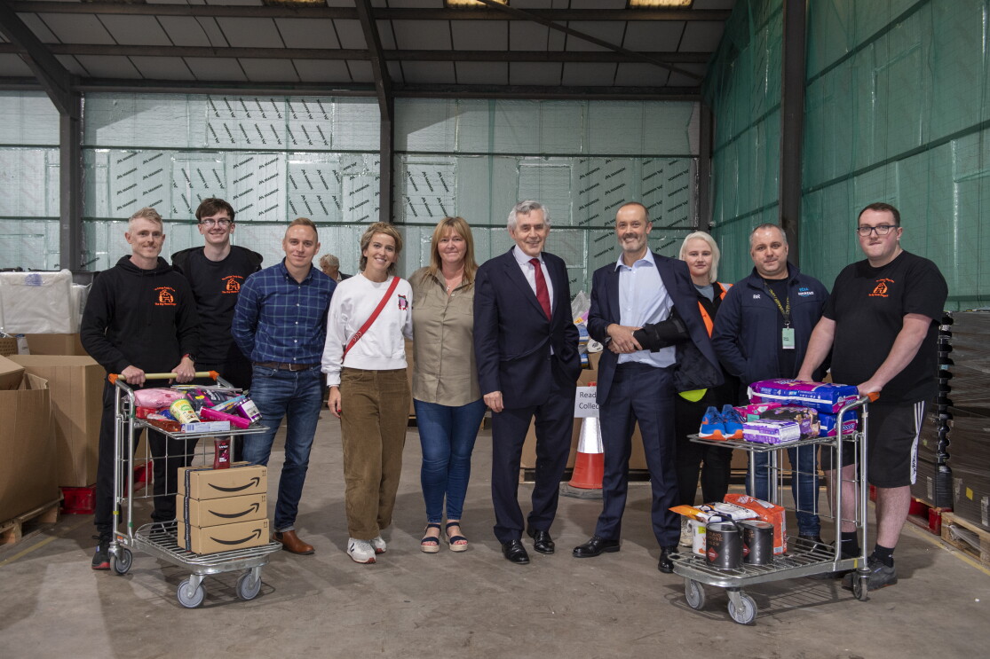 A group of volunteers holding trolleys with donations