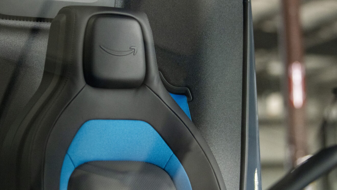A steering wheel and vehicle seat bearing the Amazon smile logo.