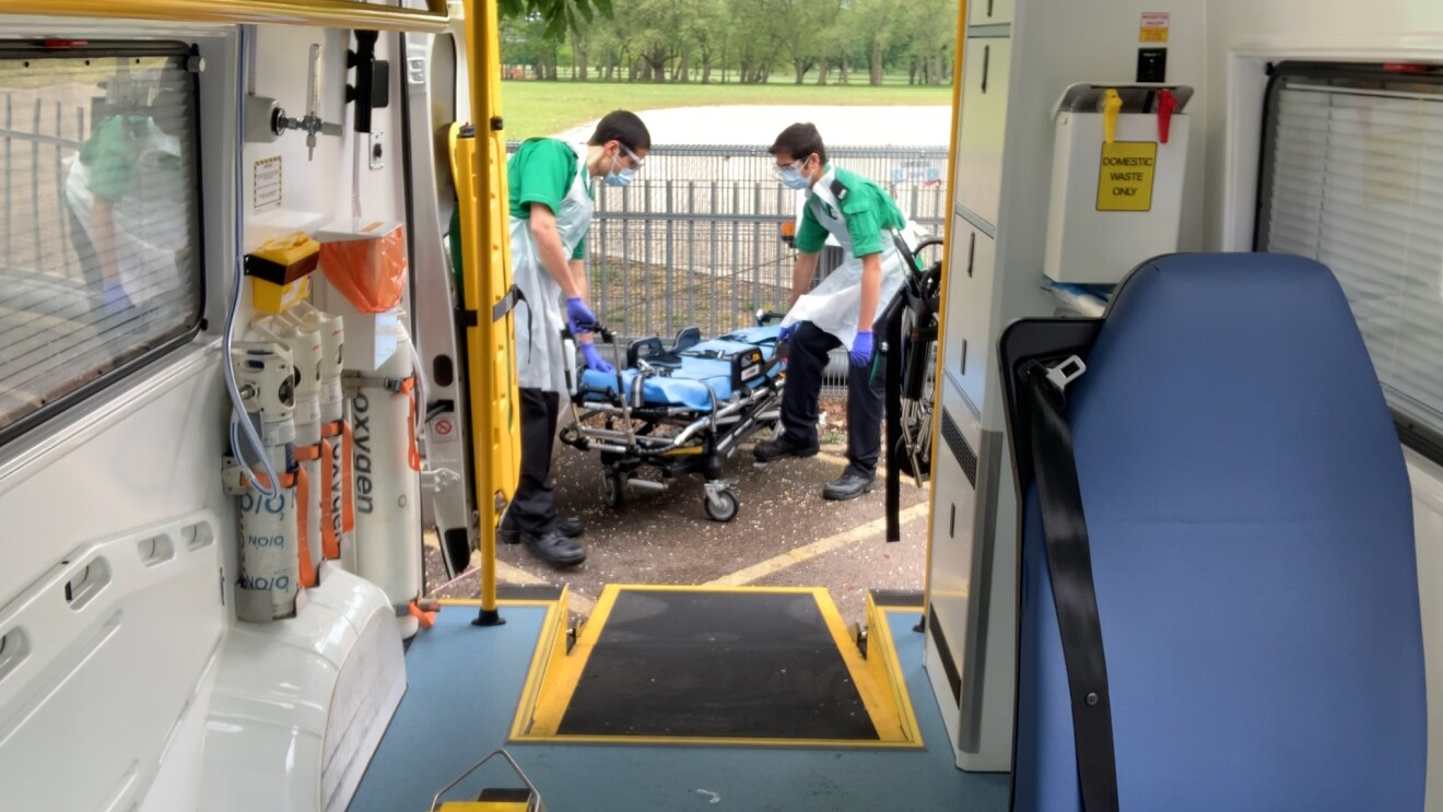 Back of an ambulance with paramedics at work in shot 