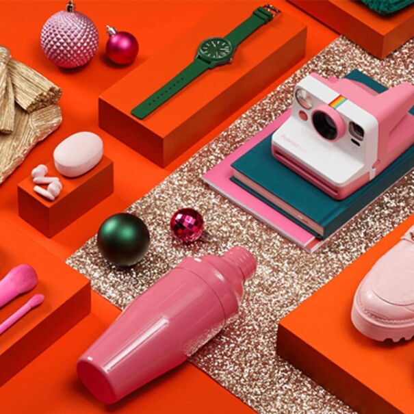 A flatlay of pink and green themed gift items arranged on a red background.