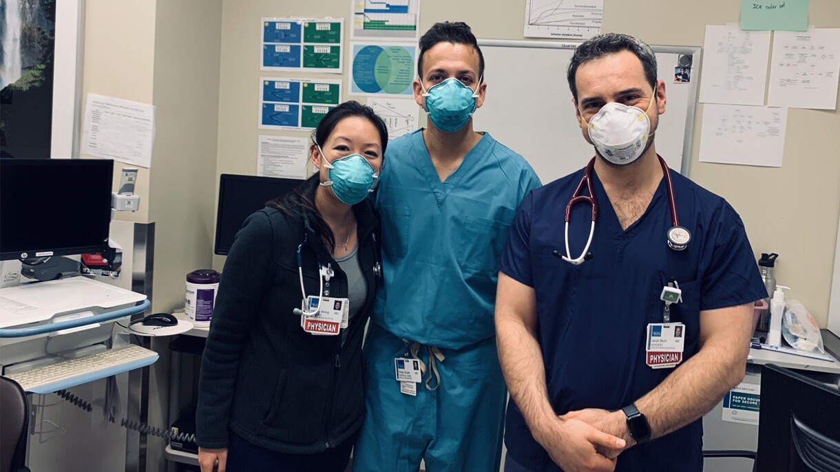 Una fotografía del Dr. Gupta y dos colegas en un hospital. Todos usando cubrebocas.