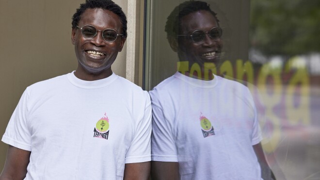 一个男人微笑着靠在店面的形象窗口。