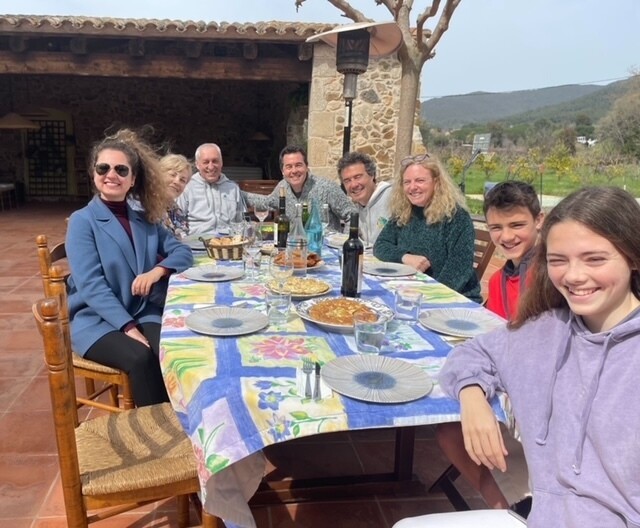 Daria sits a dinner table outside in Spain alongside her parents, and an Amazon colleague and his family.