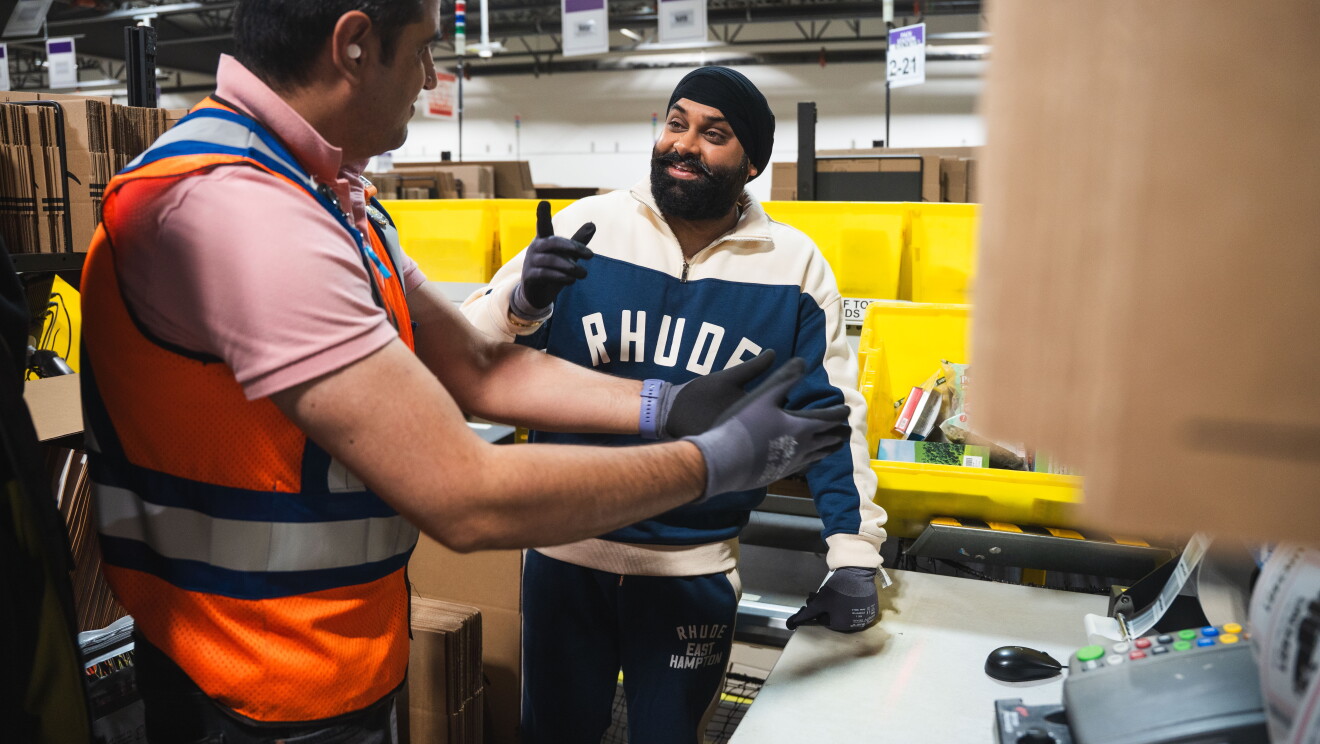Nattan talking with an Amazon employee in a warehouse