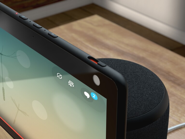 An image of an Echo Show device sitting on a table with a prominent view of the buttons on the top.