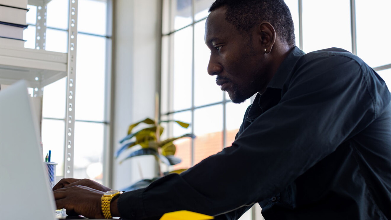 Professional man focused on computer screen in bright office space