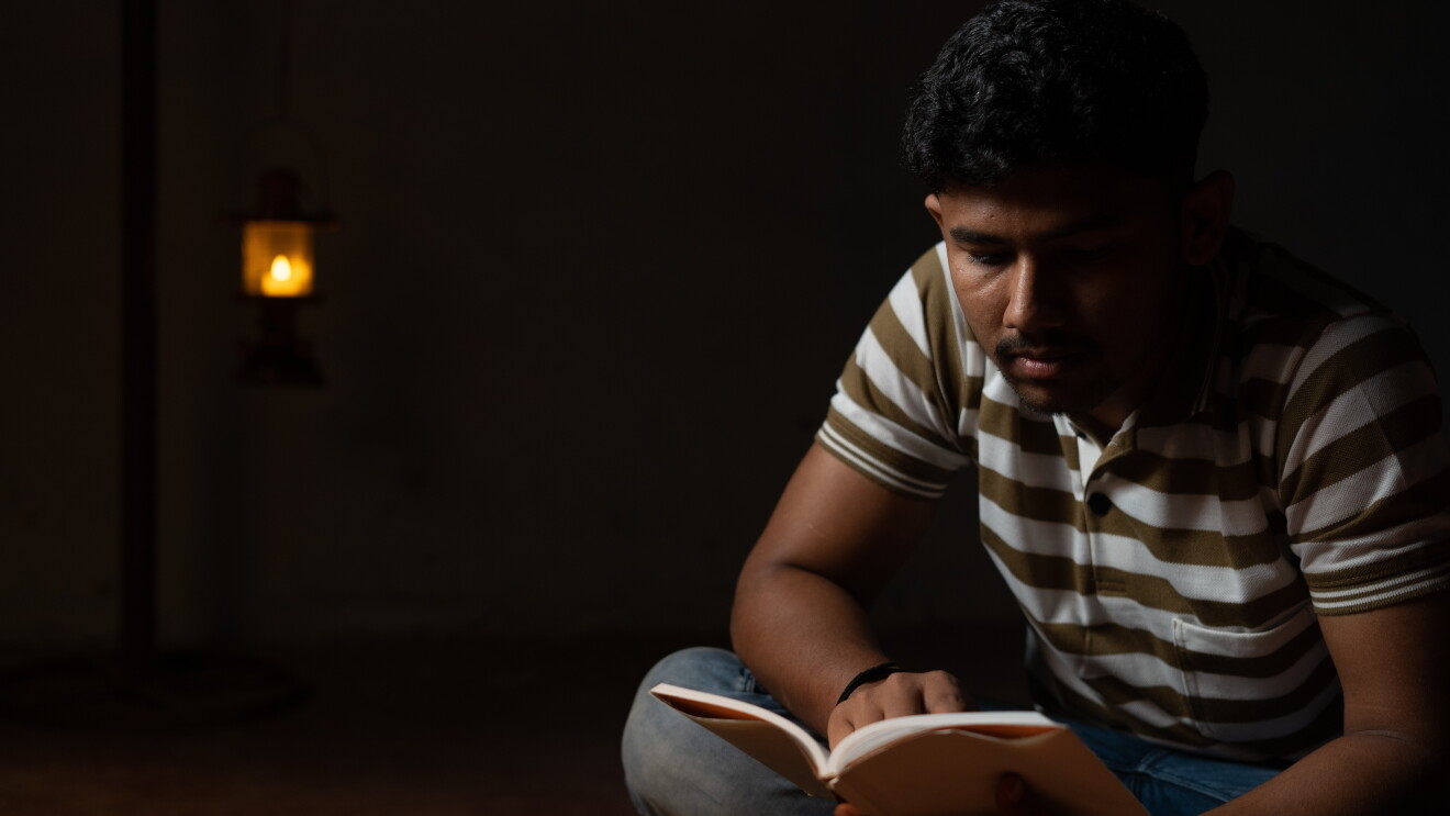 Student studying under lamp due to power cut