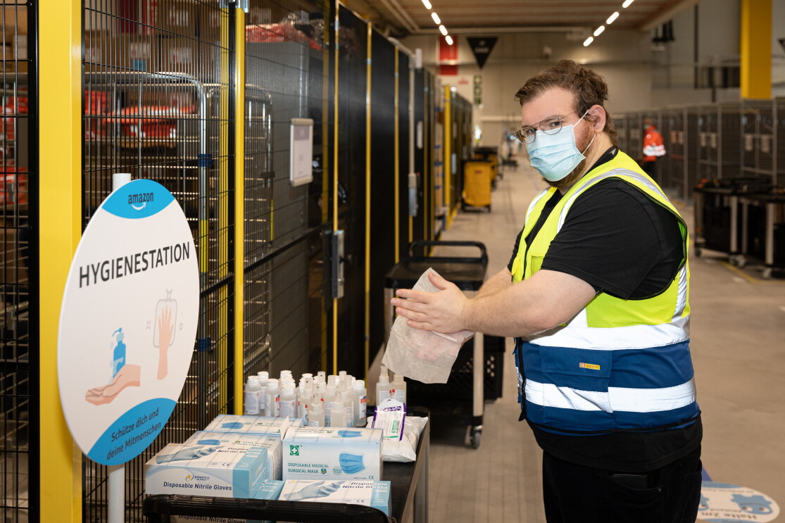 Ein Mitarbeiter an der Hygienestation beim Desinfizieren der Hände.