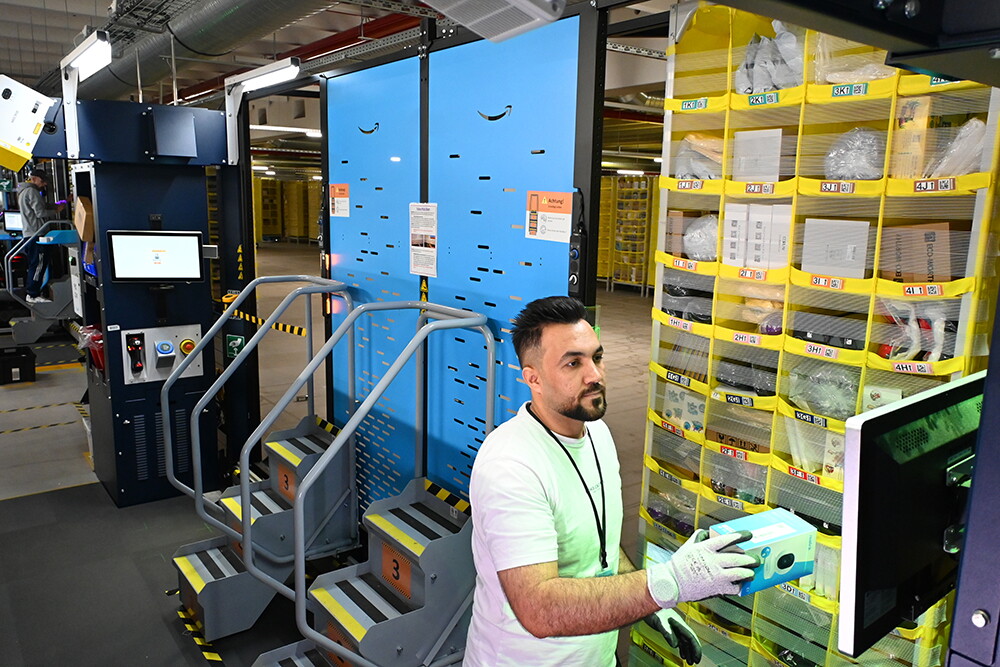 Ein Logistikmitarbeiter schaut auf einen Bildschirm und scannt einen Artikel. 