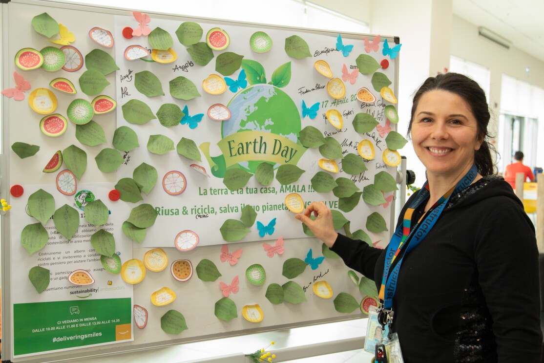 Dipendente del centro di distribuzione Amazon di Passo Corese attacca un post-it su una lavagna in occasione dell'Earth Day